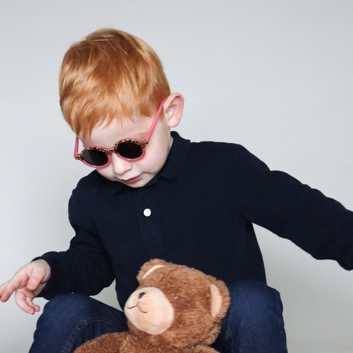 Paire de lunettes de soleil bébé catégorie 4, monture en TPEE effet transparent couleur rose avec motif léopard sur le haut. Mise en situation portée