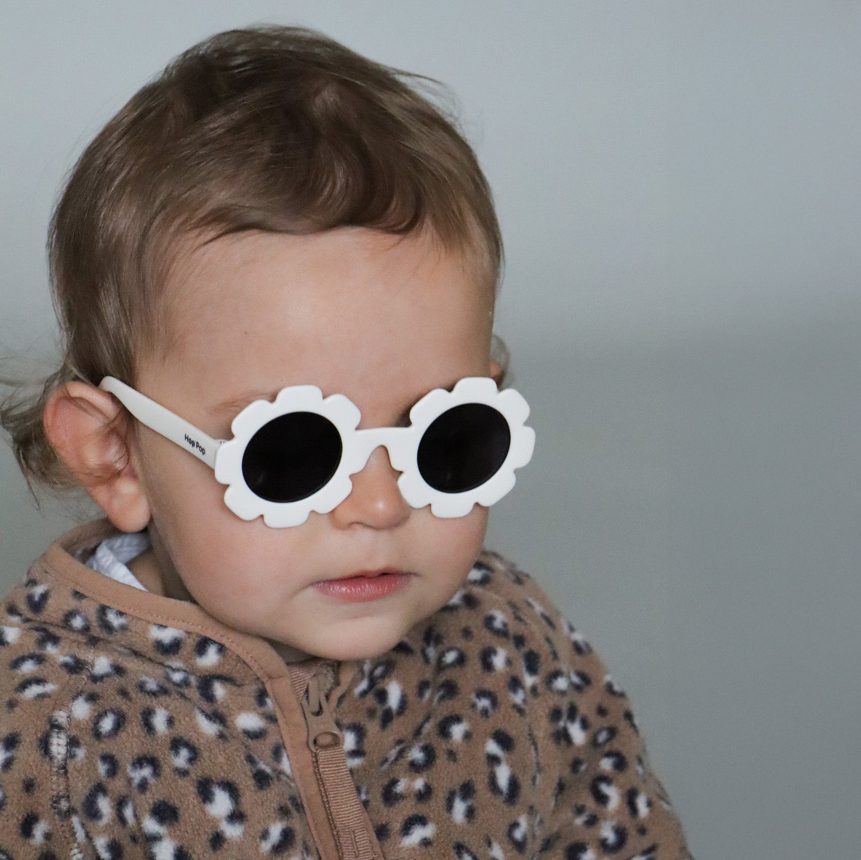 Paire de lunettes de soleil bébé catégorie 4, monture en TPEE blanc en forme de fleur. Mise en situation portée vue rapprochée