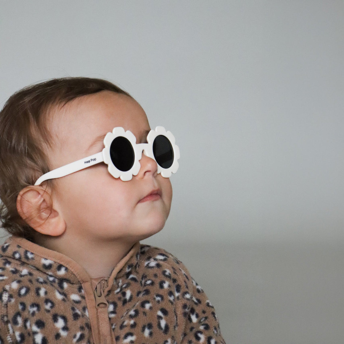 Paire de lunettes de soleil bébé catégorie 4, monture en TPEE blanc en forme de fleur. Mise en situation portée de profil