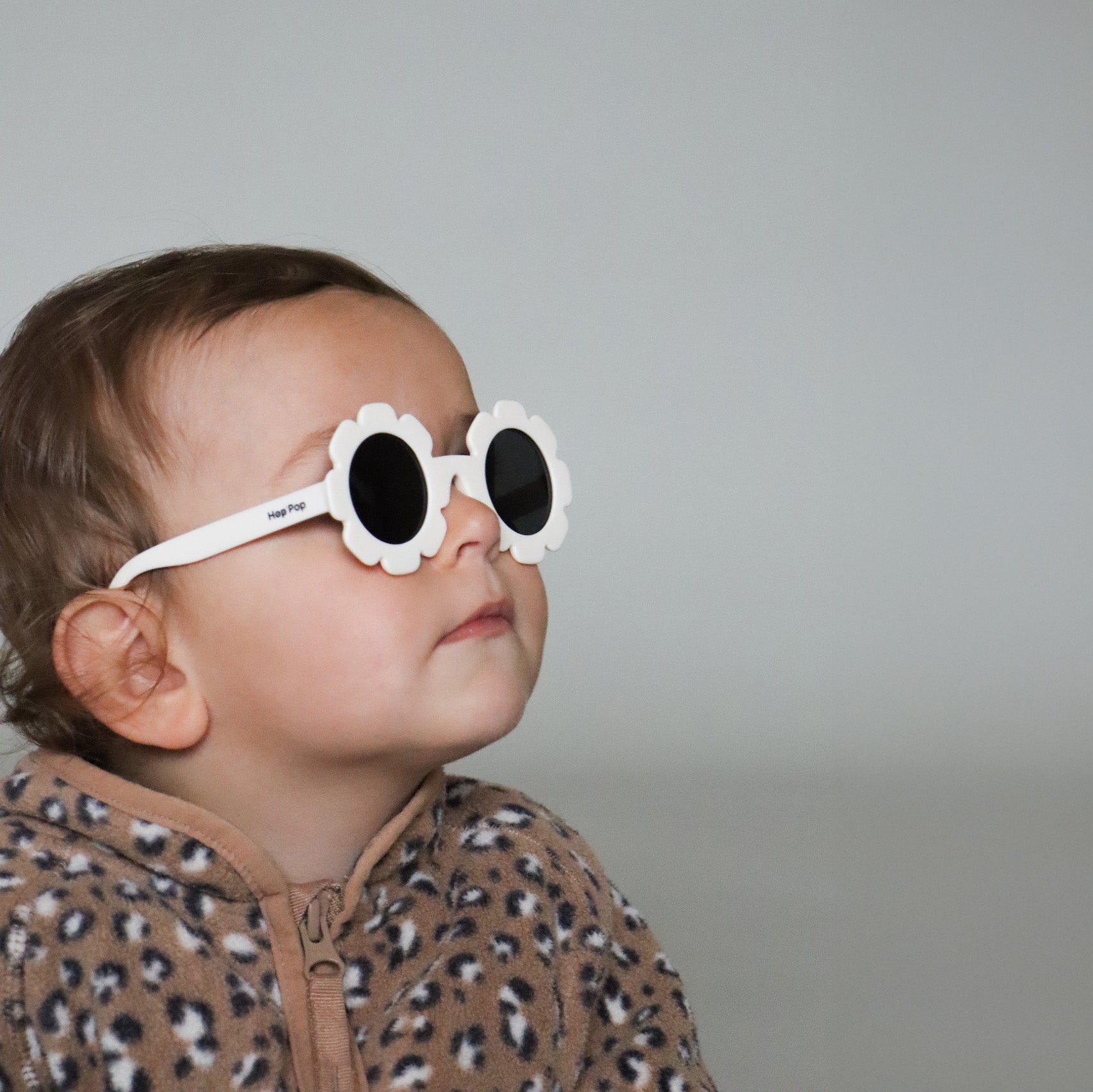 Paire de lunettes de soleil bébé catégorie 4, monture en TPEE blanc en forme de fleur. Mise en situation portée de profil